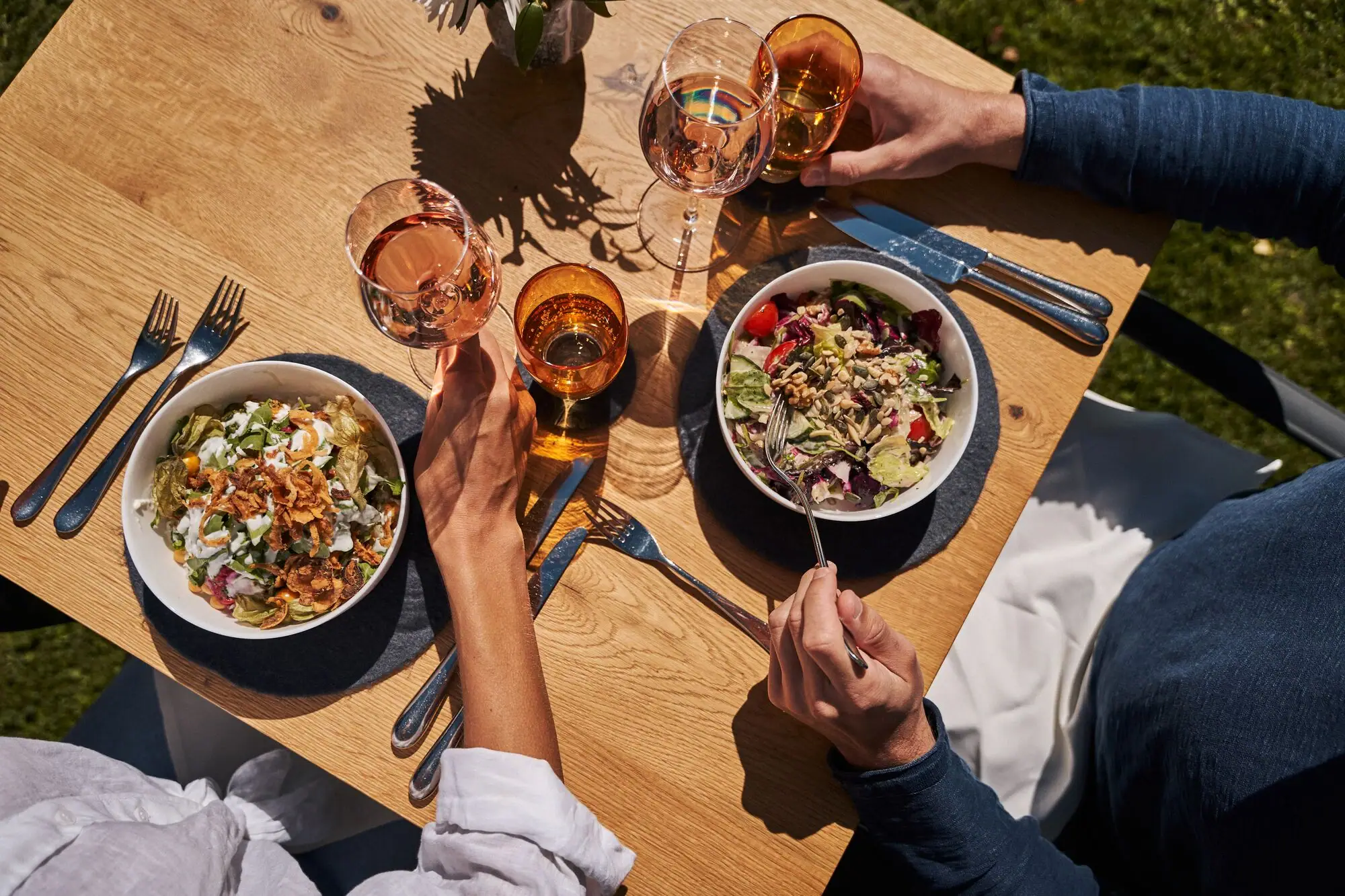 Gastentuin Een groep mensen aan een tafel met eten en drinken.