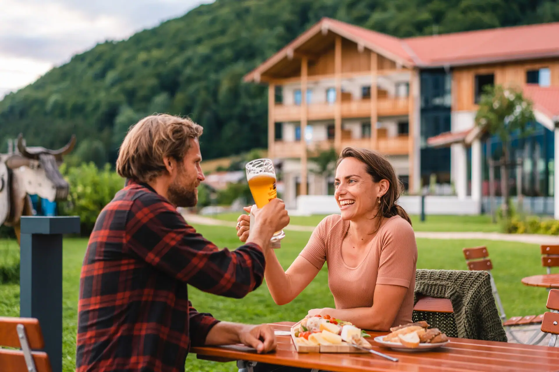 Een man en een vrouw zitten aan een tafel met eten en drinken.