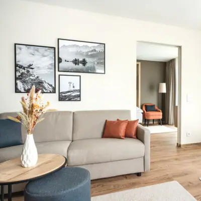 Woonkamer Een woonkamer met banken en fauteuils.