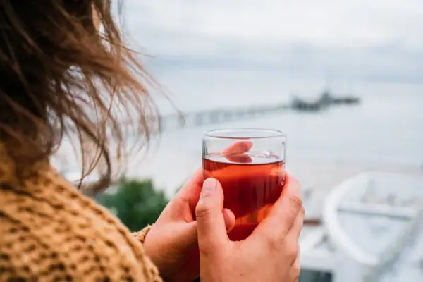 Eine Person hält ein Glas mit einem Getränk.