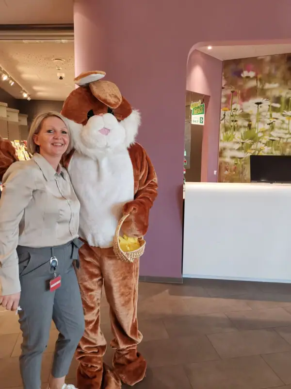 Een vrouw staat naast een persoon in een kledingstuk.