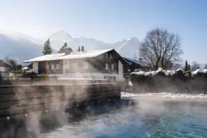 Ein Gebäude mit einem Pool und schneebedeckten Bäumen.