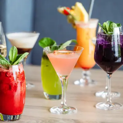 Cocktails Een groep cocktails met garnering op een tafel.