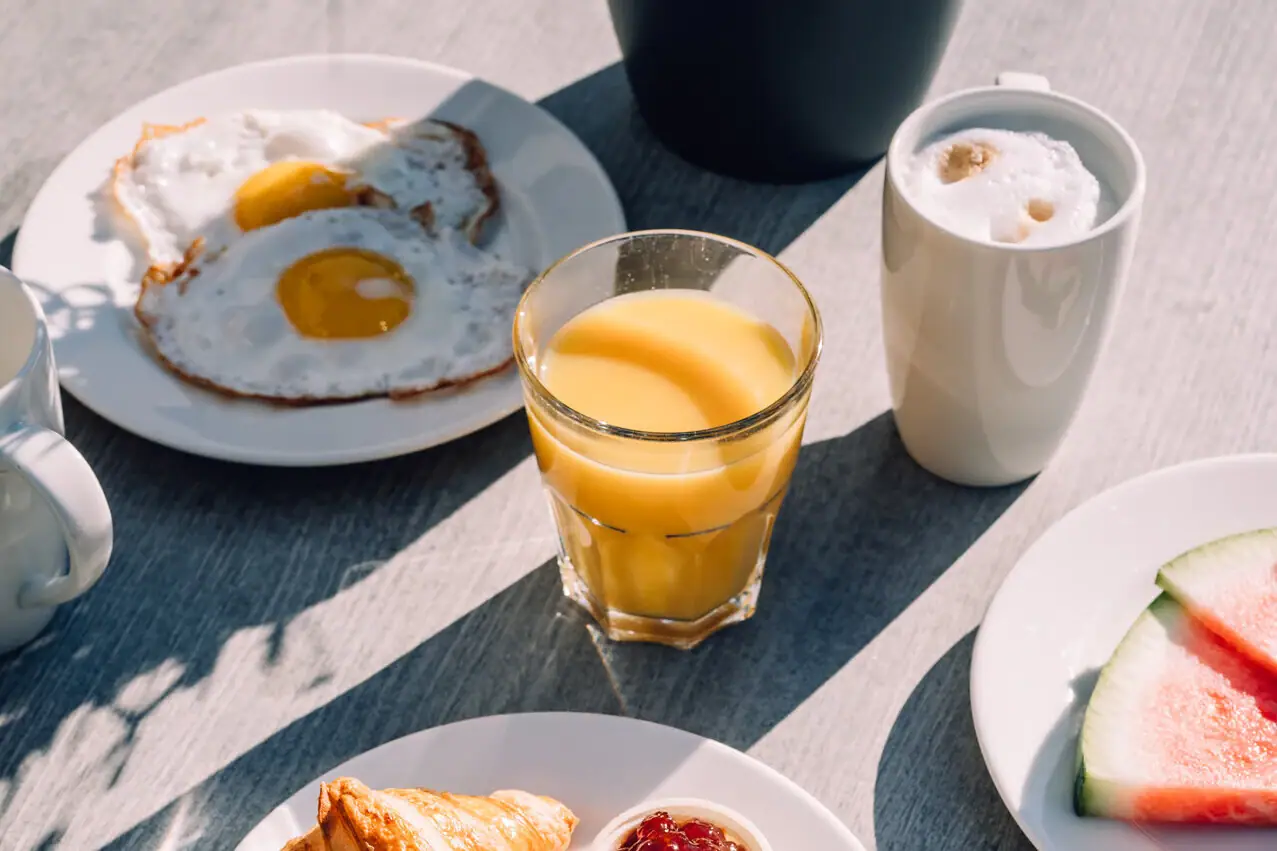 Een tafel met borden vol eten en drinken.