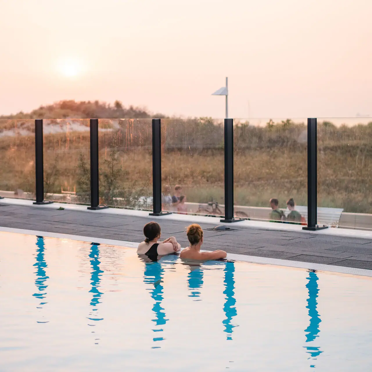 Buitenzwembad aja Warnemünde Twee mensen zwemmen in het zwembad.