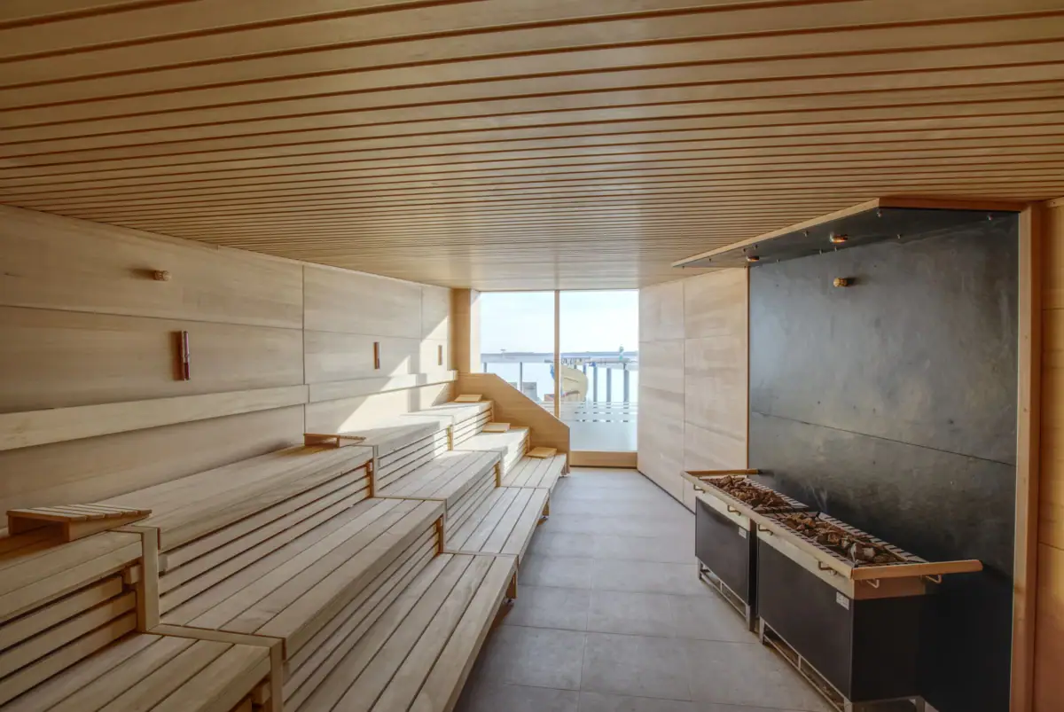 Sauna Een sauna met houten banken en een open haard.
