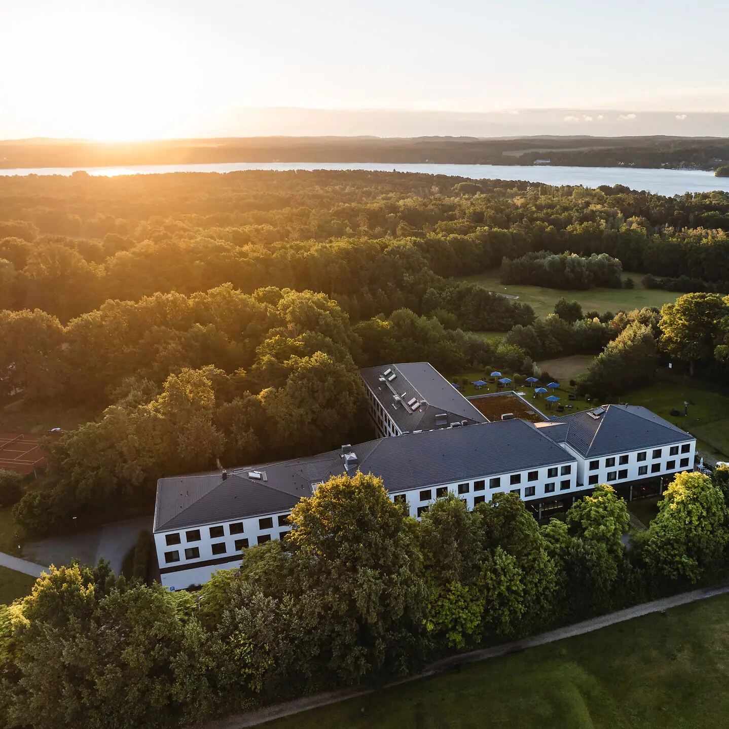 aja Bad Saarow Een gebouw omringd door bomen en water.
