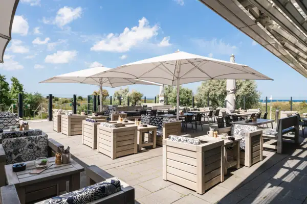 Een terras met tafels en stoelen.