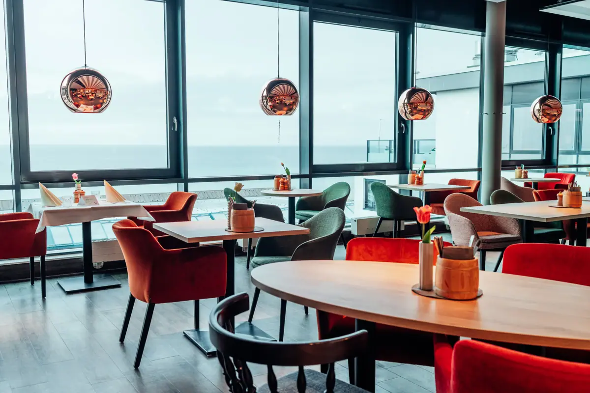 JEDERMANNS Restaurant Grömitz Een ruimte met tafels en stoelen.