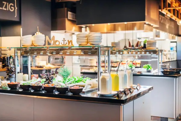 Toonbank met salades en potten gevuld met verschillende dressings.