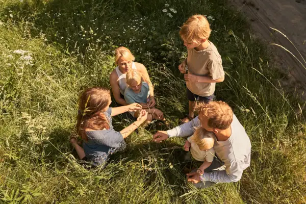 Een groep mensen zit op het gras.