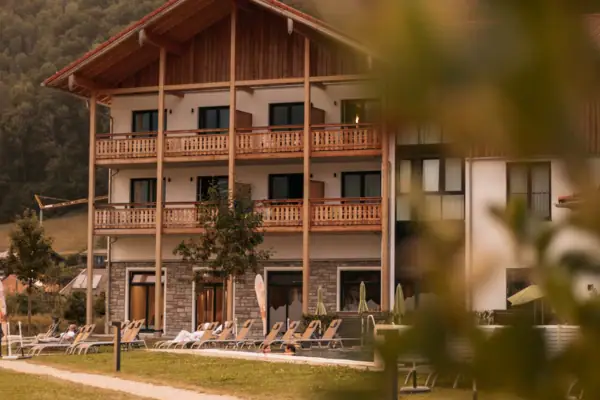 Een gebouw met een grasveld en stoelen ervoor.