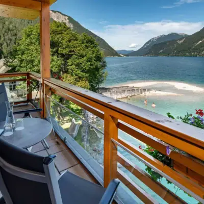 Balkon met uitzicht op het meer Een balkon met tafel en stoelen met uitzicht op het water.