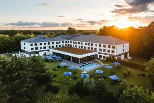 Gebouw met zwembad en parasols in het centrum.