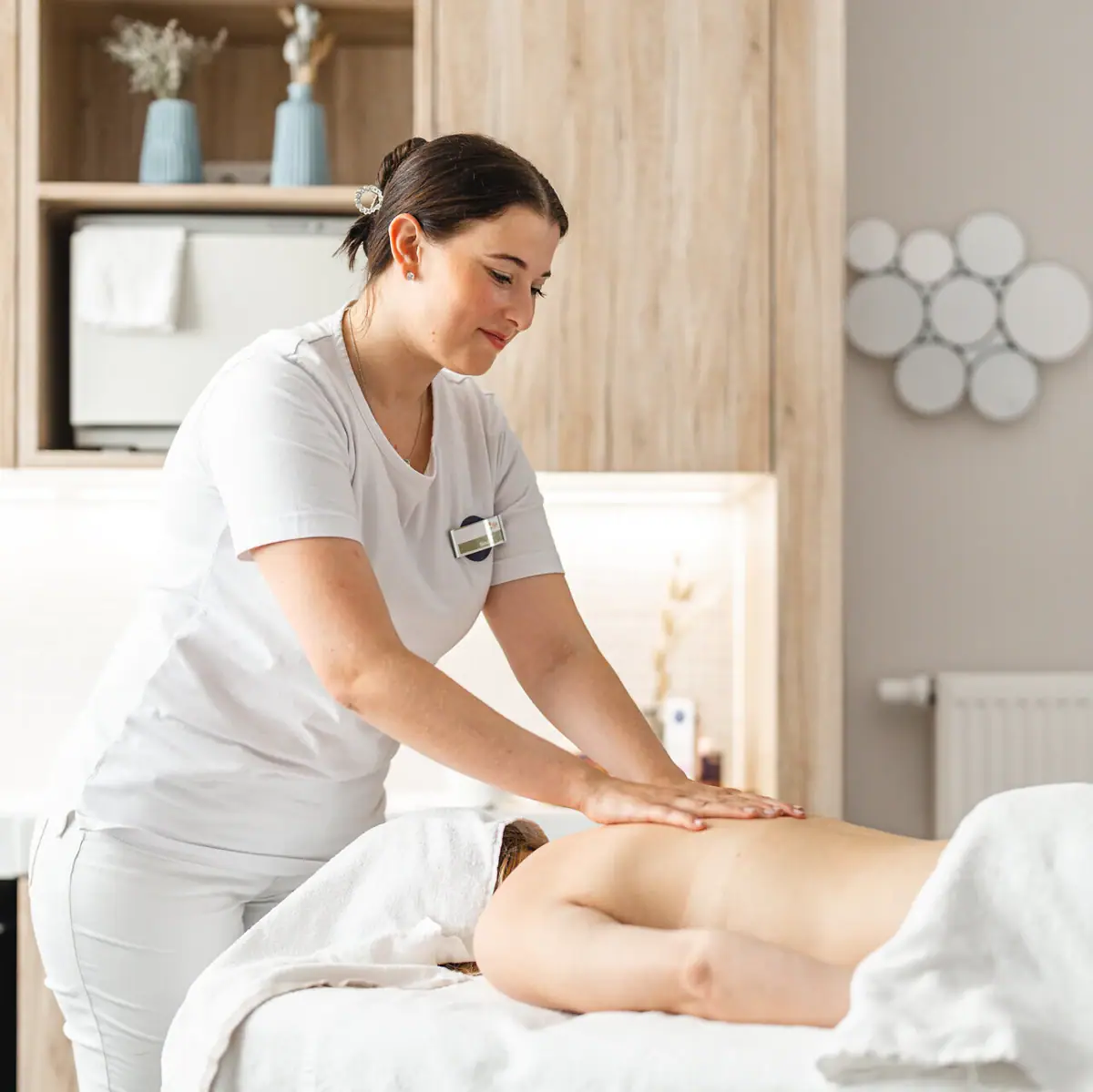 Een vrouw masseert de rug van een andere vrouw.