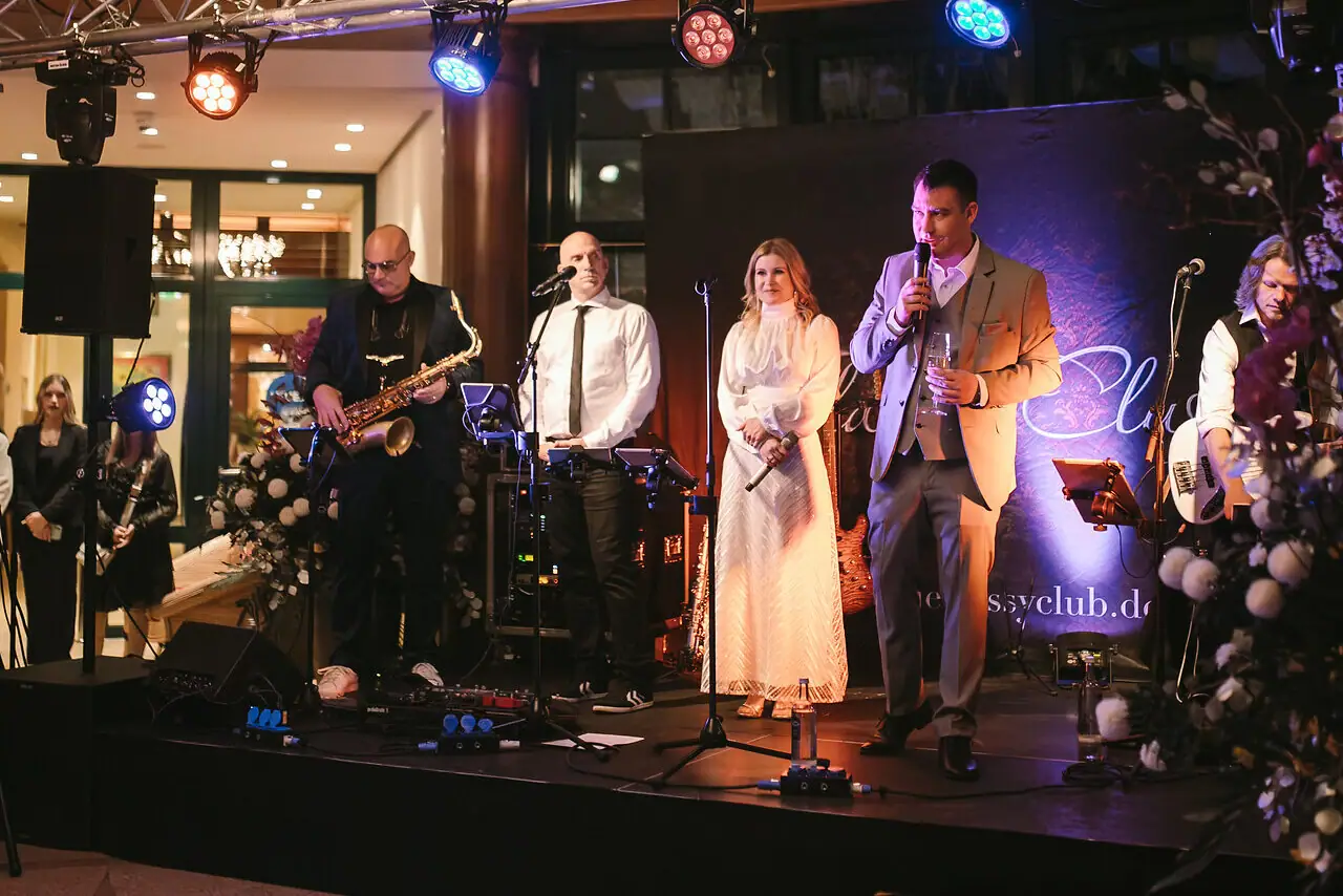 Oudejaarsavond in het aja Strandhotel Bansin Een groep mensen op een podium tijdens een concert met muziekinstrumenten.