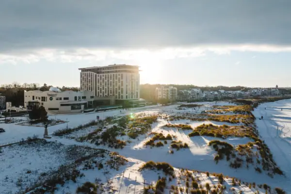 Ein schneebedecktes Feld mit dem aja Warnemünde im Hintergrund.
