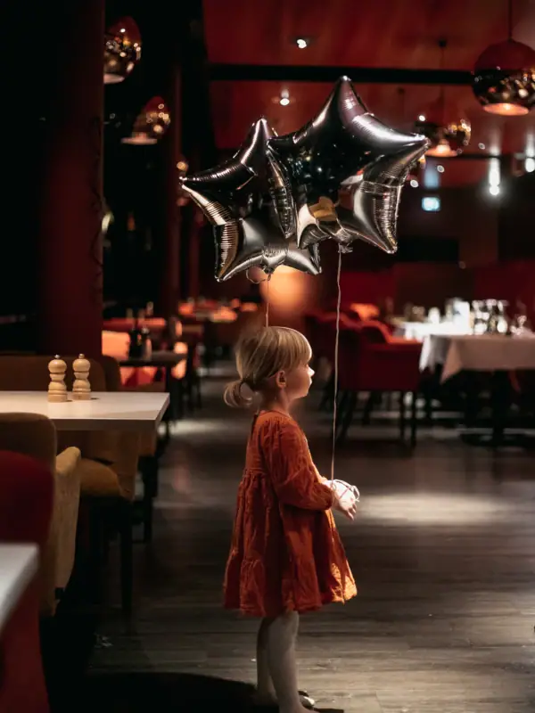 Een kind houdt een stervormige ballon vast.