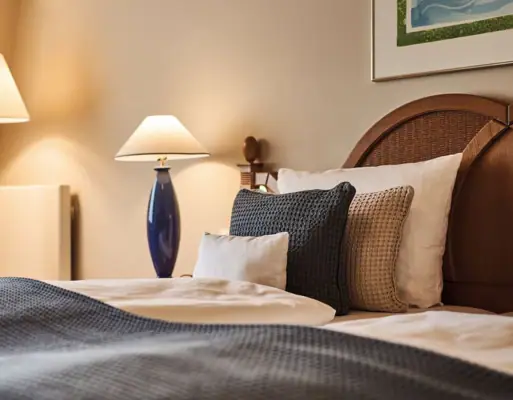 Een bed met kussens en een lamp.