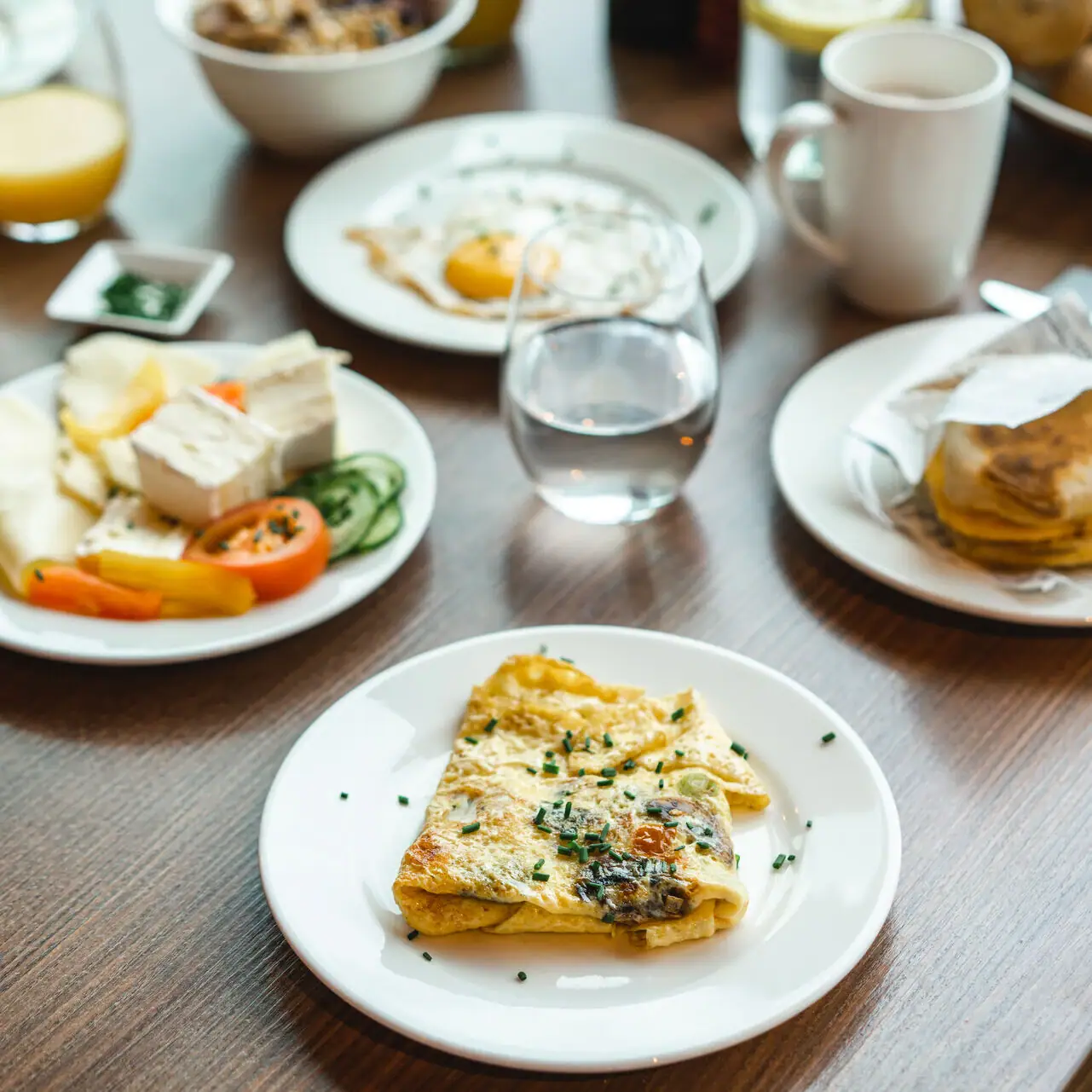 Ontbijt Een tafel met borden vol eten en drinken.