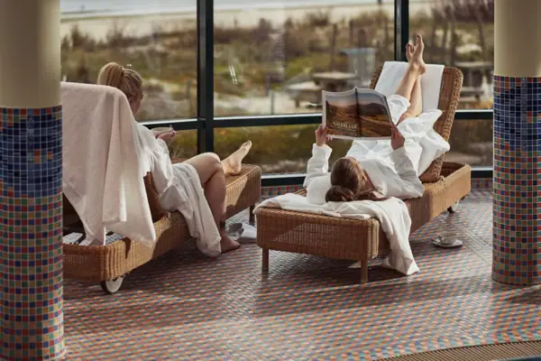 SPA Zwei Frauen in weißen Bademänteln liegen auf Stühlen.