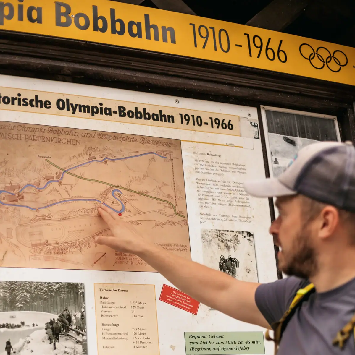 Olympische bobsleebaan Een man wijst naar een kaart.