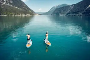 Zwei Männer auf Paddleboards auf einem See.