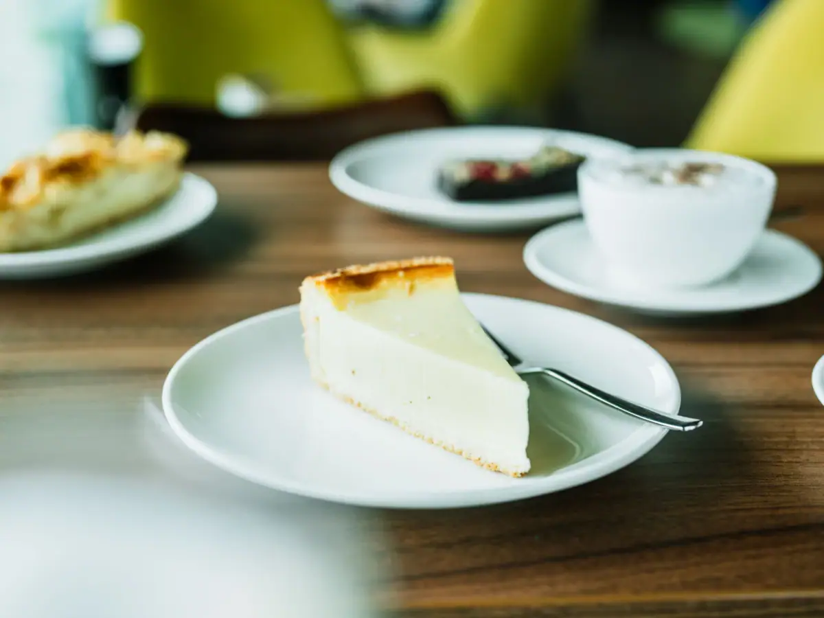 Een stuk cheesecake op een bord met een lepel.