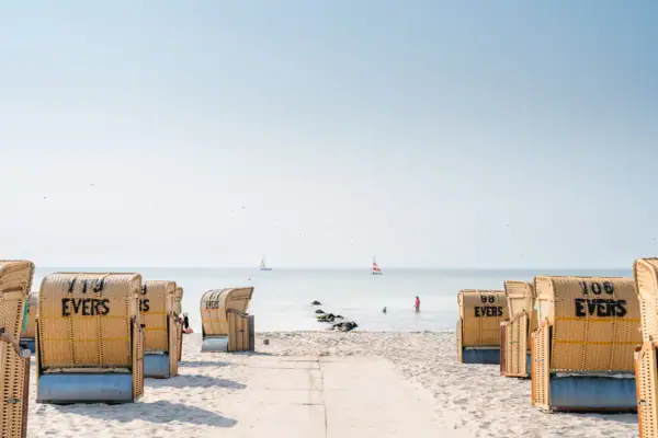 Strand met veel strandstoelen en een watermassa op de achtergrond.