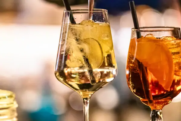 Iemand schenkt een drankje in een glas.