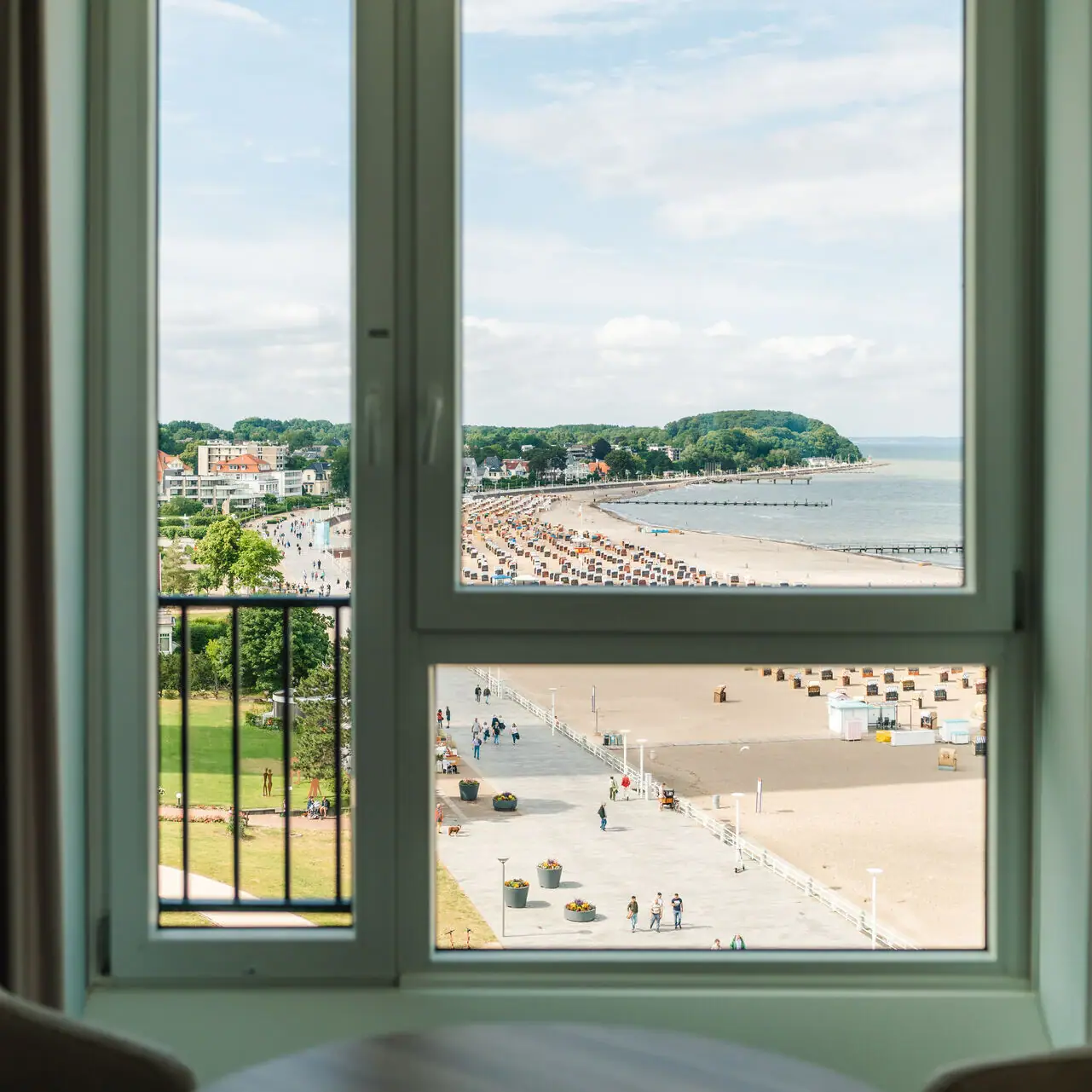 Uitzicht op een strand door een raam.