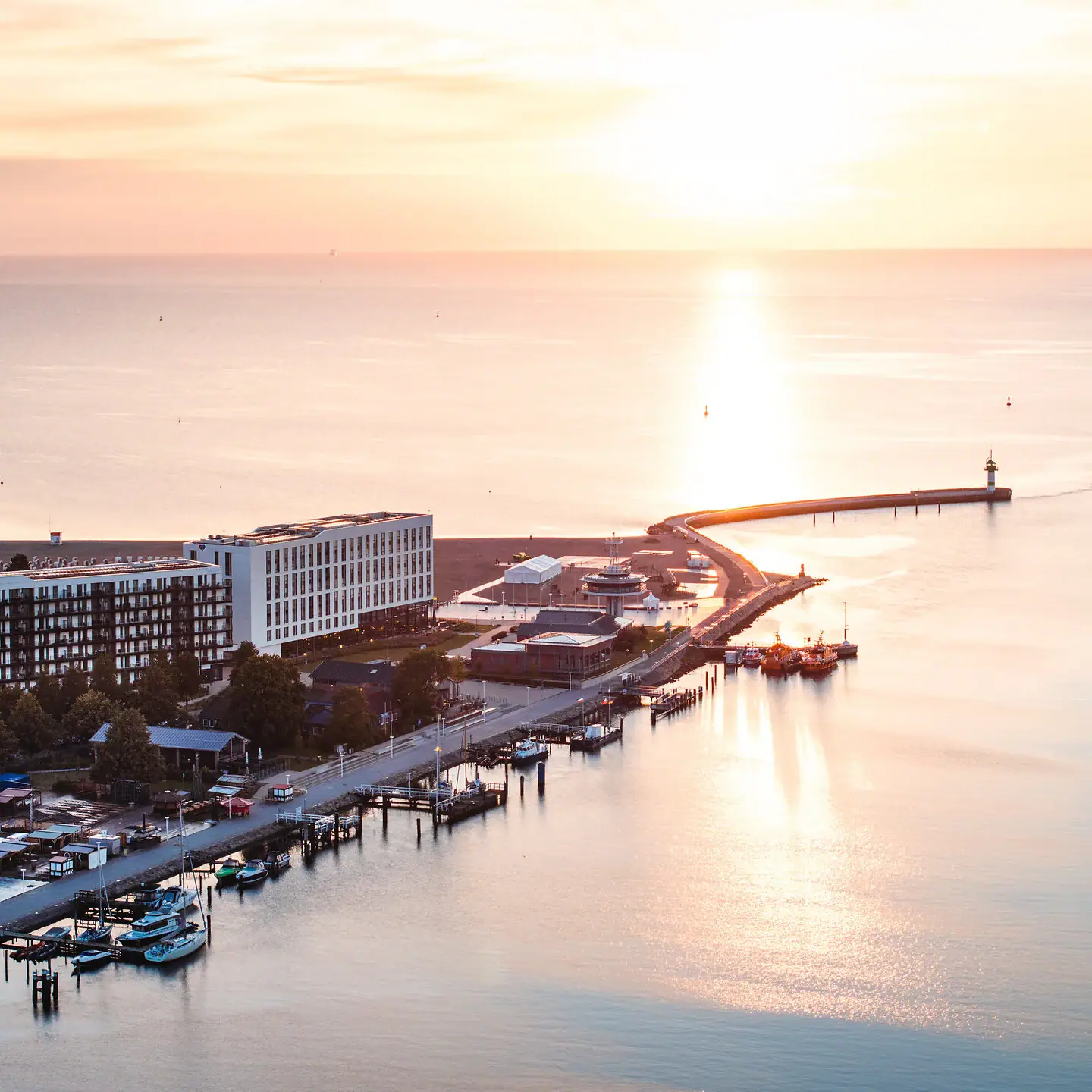 Een waterlichaam met een pier en gebouwen op de achtergrond.