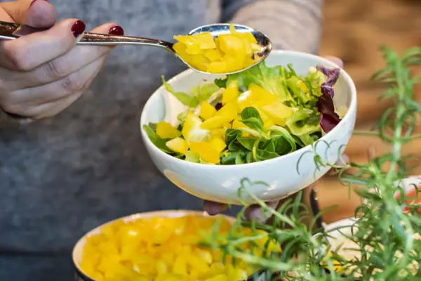 Eén persoon vult schalen met voedsel.