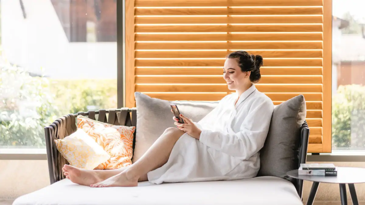 Dag SPA Een vrouw in badjas zit op een sofa.