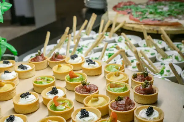 Een tafel vol hapjes, gebak en desserts.