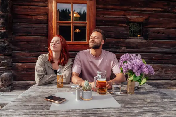 Een man en een vrouw zitten aan een tafel met drankjes.