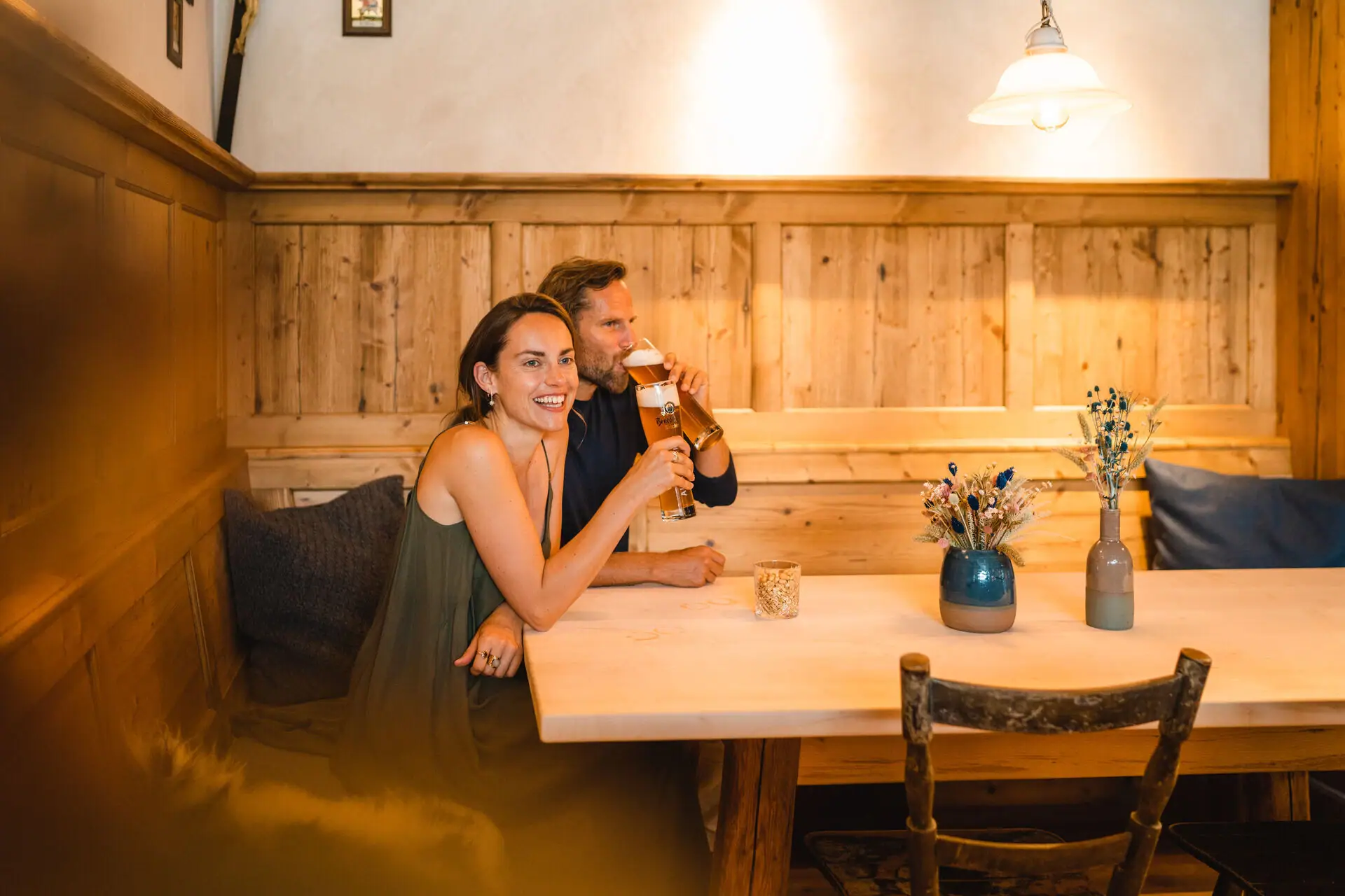 Een man en een vrouw zitten aan een tafel bier te drinken.