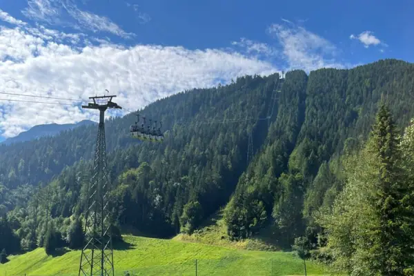 Karwendel bergtrein Elektriciteitskabel in een grasveld met bomen en blauwe lucht