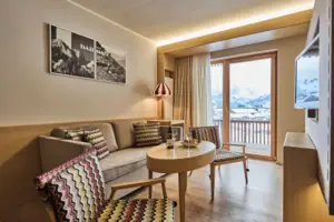 Een woonkamer met bank, tafel en stoelen.