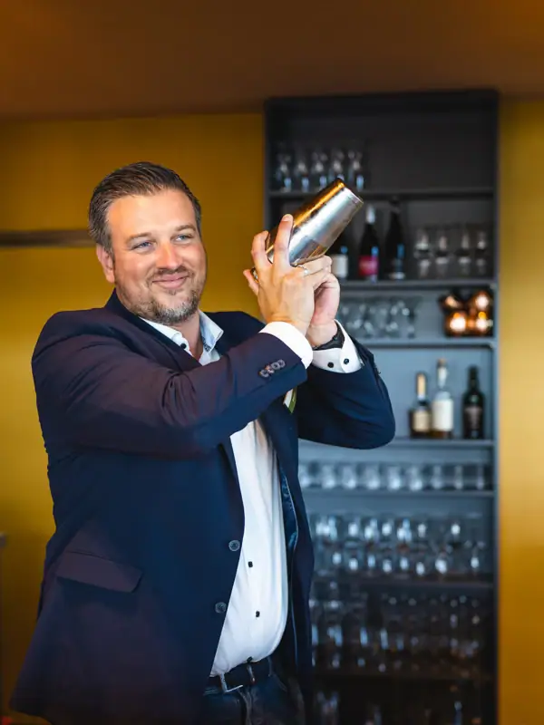 Barman Een man houdt een shaker vast.