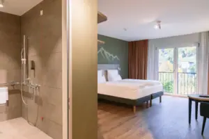 Een kamer met een bed en een douche.