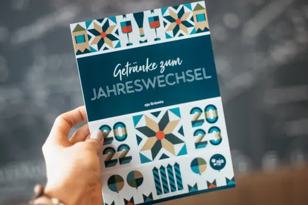 Oudejaarsavond bij aja Warnemünde Hand houdt een programmaboekje met handgeschreven notities vast.