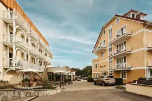 aja Nordperd & Villen Göhren Straße mit Gebäuden und geparkten Autos im Freien bei bewölktem Himmel.