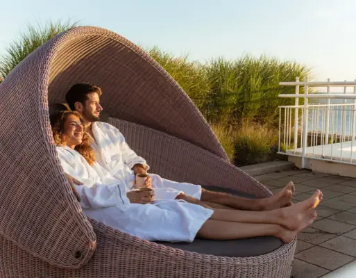Wellness Een man en een vrouw in witte gewaden zittend in een stoel.