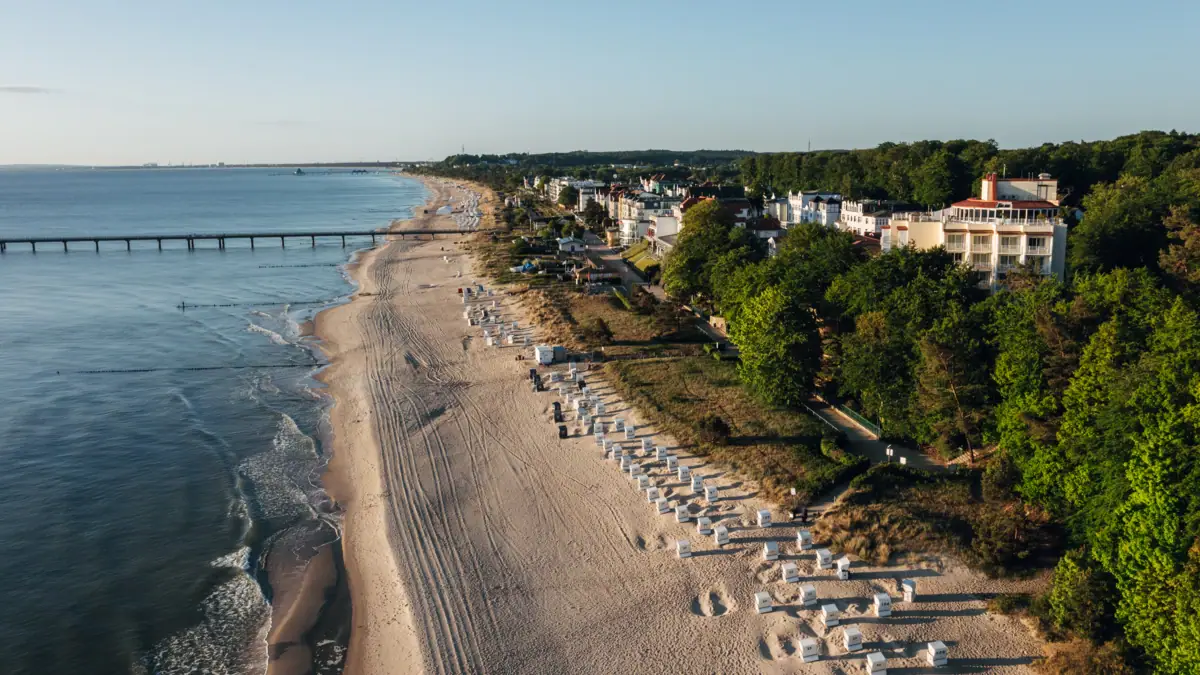 aja Strandhotel Bansin Strand met gebouwen en bomen op de voorgrond.