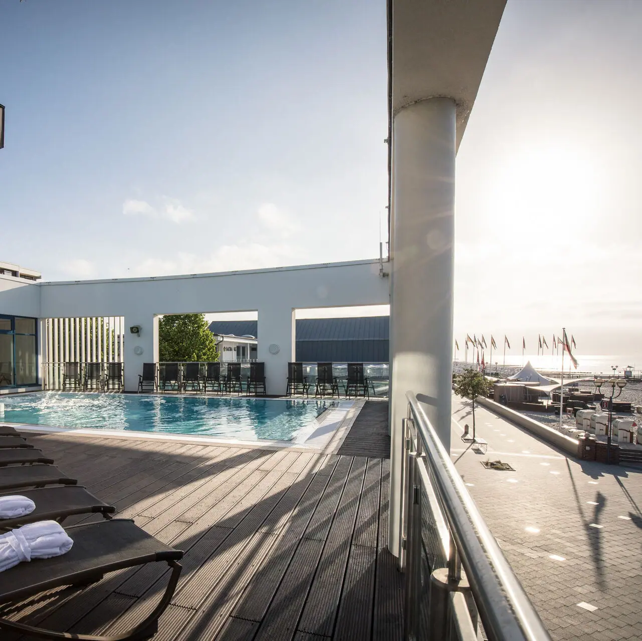 Zwembad met ligstoelen en houten buitenterras.