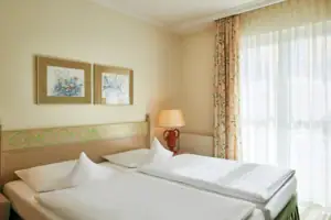 Tweepersoonskamer Landside Een kamer met twee bedden en een lamp.