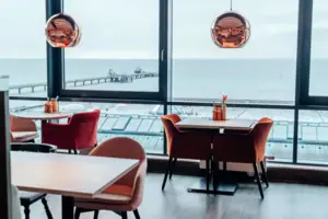 Een kamer met uitzicht op de oceaan en een pier.