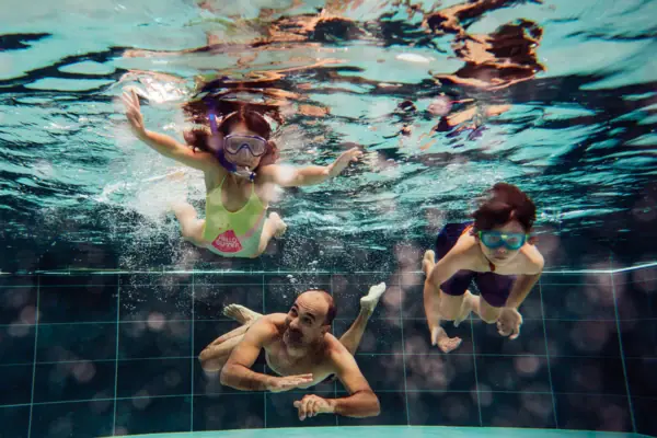 Plezier voor het hele gezin Een groep mensen zwemt onder water in het zwembad van Werfenweng.