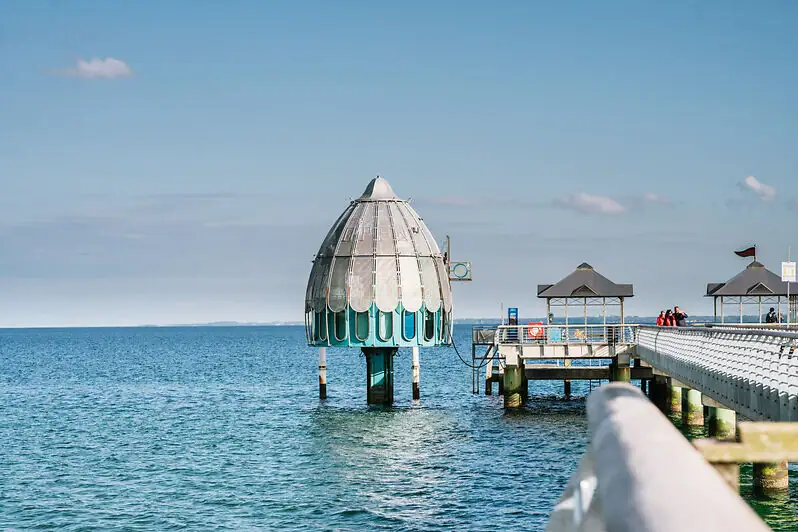 Duikgondel Een gebouw in het water onder een bewolkte hemel.